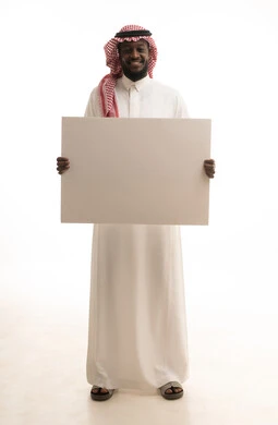 الترويج للخدمات والمنتجات، موك اب مربع أبيض, بورتريه لرجل عربي خليجي سعودي يرتدي الثوب التقليدي و الشماغ يمسك بيديه لوحة بيضاء فارغة, صورة للجسم بالطول الكامل, خلفية بيضاء