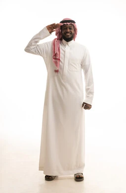 مفهوم الاستقبال والترحيب، إلقاء التحيه والسلام، بورتريه لرجل عربي سعودي يرتدي الزي التقليدي و الشماغ  يرفع يده بايماءات البشاشة، التعارف و الصداقه وتكوين العلاقات, الطول الكامل للجسم، خلفية بيضاء
