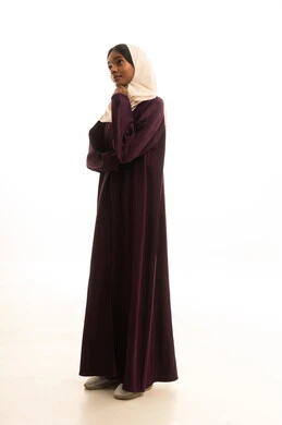 مفهوم التمعن والتركيز، ايماءات وتعابير وجه ويدين تدل على التفكير والحيرة، بورتريه لامراه عربية خليجية سعودية ترتدي العباءه والحجاب تضع يدها على ذقنها ، خلفية بيضاء