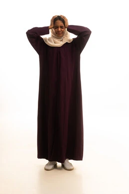 النظر بإيماءات الدهشة والاستغراب، التعجب من حصول أمر ما، بورتريه لامرأة عربية خليجية سعودية ترتدي العباءة والحجاب تضع يديها على رأسها بإيماءات تدل على الصدمة والذهول، خلفية بيضاء