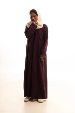 بورتريه لامراه عربية خليجية سعودية ترتدي العباءه والحجاب تضع يدها على وجهها بإيماءات الألم و وجع الأسنان، الإنتفاخ والإلتهاب بالفم واللثة، ضرورة الذهاب للطبيب والحصول على العلاج،مفهوم تسوس الأضراس,  صورة الجسم بالطول الكامل، خلفية بيضاء