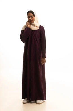 The concept of tooth decay, a portrait of a Gulf Arab Saudi woman wearing an abaya and hijab, placing her hand on her face with gestures of pain and toothache, swelling and inflammation in the mouth and gums, the necessity to see a doctor and receive treatment, a full-body image, white background.