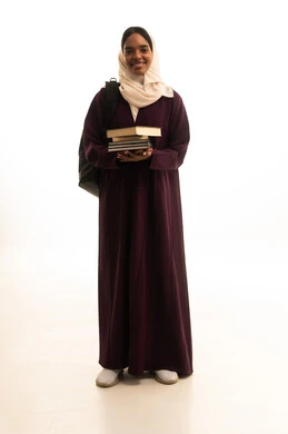 Higher education in the universities of the Kingdom, modern curricula and educational materials, preparation for the new academic year, a portrait of a Gulf Arab Saudi university student with a dark complexion wearing an abaya and hijab, carrying a backpack with a collection of books, white background.