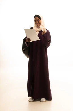 Looking with gestures of happiness and joy, preparing for the new academic year, higher education in universities and academic colleges, a portrait of an Arab Gulf Saudi university student wearing an abaya and hijab, carrying a backpack and holding papers in her hand, white background.