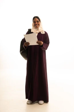 Looking with gestures of happiness and joy, preparing for the new academic year, higher education in universities and academic colleges, a portrait of an Arab Gulf Saudi university student wearing an abaya and hijab, carrying a backpack and holding papers in her hand, white background.