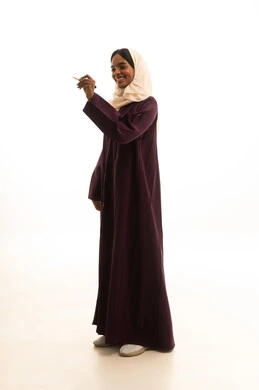 The concept of drawing and planning, the readiness to write down and define something, a portrait of a Gulf Arab Saudi university student wearing an abaya and hijab, carrying a backpack, holding a pen, gesturing with her hand as if writing in the air, a full-body image, white background.