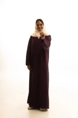Preparation to write and define something, the concept of drawing and planning, a portrait of a Gulf Arab Saudi university student wearing an abaya and hijab, carrying a backpack, holding a pen, gesturing with her hand as if writing in the air, a full-body image, white background.