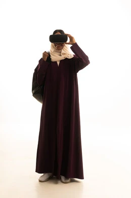 Wearing virtual reality glasses, simulating a fantasy world, using a modern and advanced technical device for entertainment and amusement, a portrait of a Saudi Arabian Gulf woman wearing an abaya and hijab, wearing 3D VR glasses, white background.