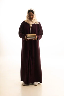 A portrait of a Gulf Arab Saudi university student with a dark complexion wearing an abaya and hijab, carrying a backpack filled with books. Higher education in the universities of the Kingdom, modern curricula and educational materials, preparation for the new academic year, white background.