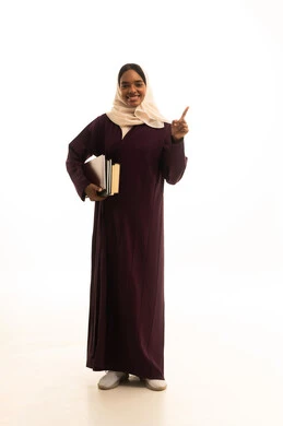 Pointing with the index finger at something, higher education in the universities of the Kingdom, modern curricula and educational materials, preparation for the new academic year, a portrait of an Arab Gulf Saudi university student with a dark complexion wearing an abaya and hijab, carrying a backpack with a collection of books, white background.
