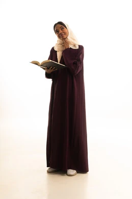 تعابير التفكير والحيرة والتأمل ، التعليم الجامعي في المملكة العربية السعودية ،  بورتريه لطالبة جامعية عربية خليجية سعودية ترتدي العباءه والحجاب تحمل بيدها كتاب جامعي، قراءة الكتب المفيدة، خلفية بيضاء .