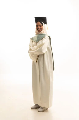 مفهوم التفوق والنجاح، التقاط صور شخصية بثياب التخرج، الاحتفال بإنهاء المرحلة الجامعية، بورتريه لطالبة عربيه خليجيه سعوديه ترتدي روب التخرج والقبعة وعباءة التخرج تنظر بتعابير السرور، خلفية بيضاء