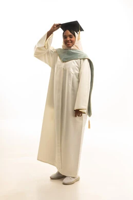 A portrait of a Gulf Arab Saudi female student wearing a graduation gown, cap, and graduation cloak, looking with expressions of joy, embodying the concept of excellence and success, taking personal photos in graduation attire, celebrating the completion of her university stage, with a white background.