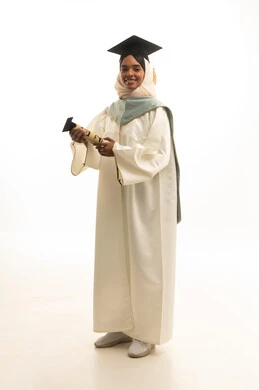 الاحتفال بإنهاء المرحلة الجامعية، مفهوم التفوق والنجاح، التقاط صور شخصية بثياب التخرج،بورتريه لطالبة عربيه خليجيه سعوديه ترتدي القبعة وعباءة التخرج تنظر بتعابير السرور، خلفية بيضاء