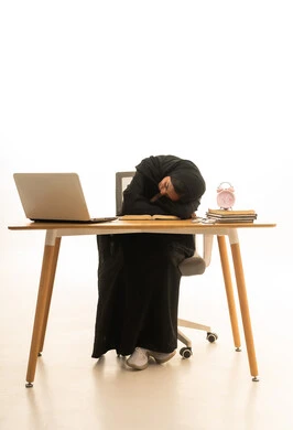 تعابير النعاس والحاجه الى النوم ، قدوم وقت الامتحانات والمذاكرات، استخدام التكنولوجيا والتقنيات الحديثة ، تطوير المناهج والمواد التعليمية في السعودية، استغلال الوقت في الدراسة والمذاكرة, بورتريه لطالبة جامعية عربية خليجية سعودية ترتدي العباءة والحجاب امام ساعة منبه وكتب وجهاز الحاسوب المحمول , خلفية بيضاء.