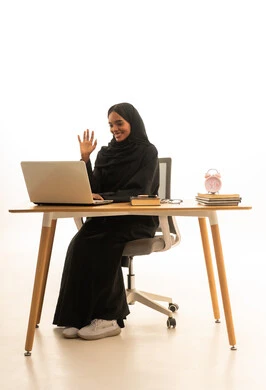 ايماءات التحية والسلام ، مفهوم التعليم عبر الانترنت ، استخدام التكنولوجيا والتقنيات الحديثة فى العمل ، بورتريه لطالبة عربيه خليجيه سعوديه ترتدي العباءه والحجاب تستخدم جهاز اللابتوب ، تتابع حصص الاونلاين عن طريق اللابتوب، خلفية بيضاء