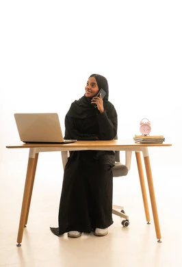 اجراء مكالمة هاتفية ،التعلم عن بعد ، مفهوم التعليم عبر الانترنت ، استخدام التكنولوجيا والتقنيات الحديثة فى العمل ، بورتريه لطالبة عربيه خليجيه سعوديه ترتدي العباءه والحجاب تستخدم جهاز اللابتوب ، تتابع حصص الاونلاين عن طريق اللابتوب، خلفية بيضاء