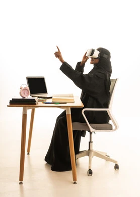 استخدام التكنولوجيا والتقنيات الحديثة، تحديد هدف معين ، قدوم وقت الامتحانات والمذاكرات، مفهوم البحث والاستكشاف حول العالم, بورتريه لطالبة عربية خليجية سعودية ترتدي العباءة والحجاب ونظارات الفى ار تجلس على الطاولة امام مجسم الكرة الارضية والكتب والحاسوب المحمول ، خلفية بيضاء