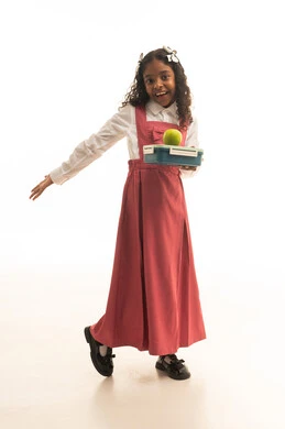 جودة التعليم في مدارس المملكة العربية السعودية، مفهوم الجد والاجتهاد للوصول إلى النجاح، العودة الى المدارس، بورتريه لطالبة عربيه خليجيه سعودية مبتسمه ترتدي الزي المدرسي تحمل صندوق الطعام مع تفاحة خضراء، صورة لكامل الجسم، خلفية بيضاء