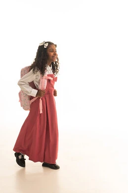 الذهاب الى المدرسة بتعابير السرور والحماس, الرغبة في طلب العلم، التجهيز لبداية العام الدراسي, موسم العوده للمدارس, بورتريه من الجانب لطالبة عربية خليجية سعودية ترتدي اليونيفورم المدرسي تحمل الحقيبة المدرسية,  الطول الكامل للجسم، خلفية بيضاء