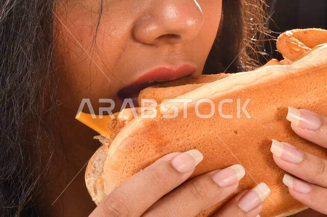  ساندويش الصامولي بحلقات البصل مع الجبنه الذائبه,  إمرأه عربيه سعوديه خليجيه تتناول ساندويش لذيذ, الاستمتاع باكل المأكولات السريعه, اضرار الاكثار من  تناول الوجبات السريعه