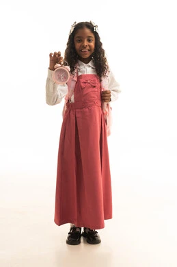 Time management and the concept of organizing it, preparation for the new school year, education in the Kingdom of Saudi Arabia, a portrait of a Gulf Arab Saudi girl wearing a school uniform holding an alarm clock in one hand and carrying a school bag, white background.