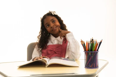 أهمية التعليم في بناء مستقبل مشرق للمجتمع ، مفهوم البحث والإستكشاف حول العالم، بورتريه لطالبة عربية خليجية سعودية ترتدي الزي المدرسي تجلس على طاوله مكتبية تقوم بمذاكره الدروس المدرسيه، خلفية بيضاء