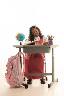 Studying school lessons, contemplation and deep thinking, using tools and aids, and the quality of effective learning methods, a close-up portrait of a Saudi Gulf Arab student wearing a school uniform sitting at a desk pointing to a globe model, white background.