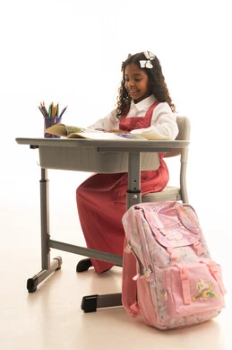 تأدية الواجبات المدرسية، دور المدارس في تحقيق النجاح والتطور الشخصي، استخدام الأدوات والوسائل المساعدة وجودة أساليب التعلم الفعال، بورتريه مقرب لطالبة عربىة خليجية سعودية ترتدي الزي المدرسي تجلس على طاوله مكتبية بجانبها مجسم الكرة الأرضية، خلفية بيضاء