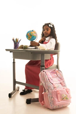 دراسة العلوم الجغرافية، مفهوم البحث والإستكشاف حول العالم، بورترية لطالبة عربيه خليجيه عمانيه ترتدي الزي المدرسي تقوم بمساك مجسم الكره الارضية، فتاه سعوديه تنظر بايماءات السعاده و السرور، الجسم بالطول الكامل، خلفية بيضاء