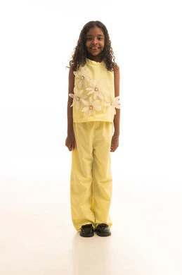 الاهتمام بالاناقة والمظهر الخارجي، النظر إلى الكاميرا بايماءات الإعجاب والرضا، الموافقة على أمر معين، بورتريه لفتاه عربية خليجية سعودية مبتسمة ترتدي الزي الكاجوال باللون الأصفرتقف بثقة وثبات اليدين على الجانب، الجسم بالطول الكامل، خلفية بيضاء