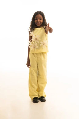 النظر إلى الكاميرا بايماءات الإعجاب والرضا، الموافقة على أمر معين، بورتريه لفتاه عربية خليجية سعودية مبتسمة ترتدي الزي الكاجوال باللون الأصفر ترفع اصبع الإبهام للأعلى بتعابير علامة الجودة، الجسم بالطول الكامل، خلفية بيضاء