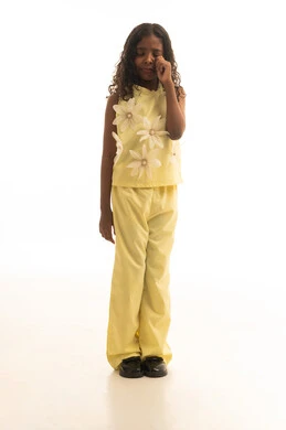 الشعور بالوحدة والقلق، الشعور بالإنزعاج والخذلان والاكتئاب، ايماءات الحزن واليأس، بورتريه لفتاه عربية خليجية سعودية ترتدي الزي الكاجوال باللون الاصفر تضع يدها على وجهها بتعابير البكاء، فقدان وخسارة شيء ما، الجسم بالطول الكامل، خلفية بيضاء