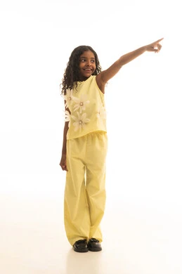 الاشارة لشيء مافي الاعلى , رؤية الاشياء البعيدة، أهداف وطموحات مستقبلية، بورتريه لفتاة عربية خليجية سعودية ترفع يدها وتشير باتجاه الهدف، بنت سعودية ترتدي الزي الكاجوال باللون الاصفر، متعة الاستكشاف والمغامرة، صورة الجسم بالطول الكامل، خلفية بيضاء