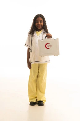 التعامل مع الإصابات الشائعة و حالات الطوارئ ، بورتريه لطفلة عربية خليجية سعودية ترتدي المعطف الطبي الخاص بمهنة الطب ، تحمل بيدها حقيبة إسعافات أولية بإيماءات تدل على السعادة ، علاج أولي سريع ، مهن مستقبلية مهمة  ، خلفية بيضاء