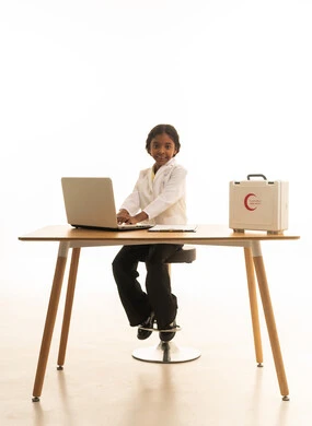 مهن ووظائف مستقبلية،دمج التكنولوجيا الحديثة في المجال الطبي، حقيبة الإسعافات الأولية، بورتريه مقرب لطفلة عربية سعودية خليجية ترتدي زي الطبيبة تقوم بتدوين ملاحظات المرضى،  خلفية بيضاء