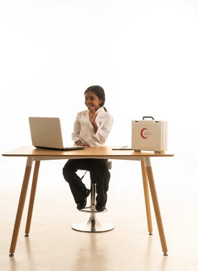 مهن ووظائف مستقبلية،دمج التكنولوجيا الحديثة في المجال الطبي، حقيبة الإسعافات الأولية، بورتريه مقرب لطفلة عربية سعودية خليجية ترتدي زي الطبيبة تقوم بتدوين ملاحظات المرضى،  خلفية بيضاء