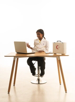 Integrating modern technology in the medical field, a first aid kit, a close-up portrait of a Saudi Arabian Gulf girl wearing a doctor's outfit taking notes on patients, future professions and jobs, white background.