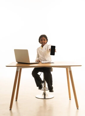 تدوين نتائج الفحوصات، الهدف والطموح المستقبلي، استخدام الاجهزة التقنية الحديثة، بورتريه مقرب لبنت  عربية خليجية سعودية  ترتدي المعطف الأبيض تجلس خلف المكتب تعمل على الحاسوب المحمول، فتاة سعودية  تقوم بإعداد التقارير، صورة لكامل الجسم، خلفية بيضاء