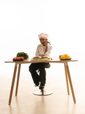 متابعة الخطوات اللازمة من كتاب وصفات الطهي الشهي, فن الطبخ وتحضير الطعام, بورتريه لطفلة عربية خليجيه سعودية ترتدي لباس الطباخ الكامل مع القبعة البيضاء تقرأ الكتاب بإيماءات السعادة, خلفية بيضاء