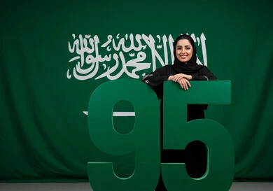 احياء الذكرى 95 لتأسيس المملكة العربية السعودية، راية التوحيد وشعار الوطن، الاحتفال بالمناسبات والأعياد الوطنية، يوم العلم 11 مارس، اليوم الوطني السعودي 23 سبتمبر، إمرأة عربية خليجية سعودية مبتسمة ترتدي الحجاب والعباءة بتعابير الاعتزاز والفخر