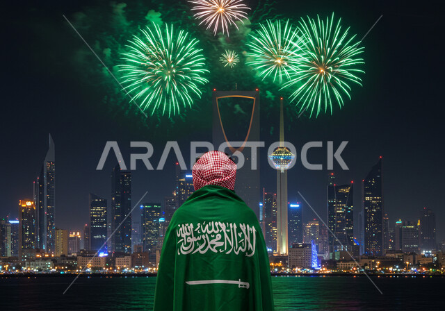 مشاهدة المفرقعات والألعاب النارية في المساء، صورة من الخلف لرجل عربي خليجي سعودي يرتدي الشماغ يضع علم المملكة العربية السعودية على كتفيه، الاحتفال بالمناسبات والأعياد الوطنية، يوم العلم 11 مارس، اليوم الوطني السعودي 23 سبتمبر، احياء الذكرى 95  للسعودية