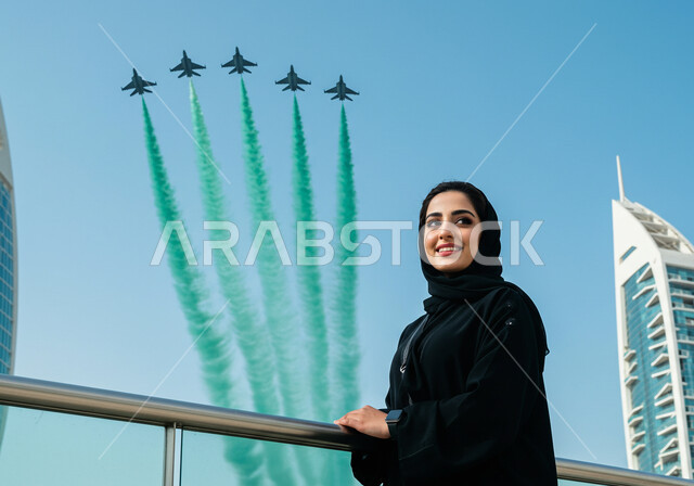  مشاهدة العرض الجوي للطائرات في احتفالات العيد الوطني، اليوم الوطني السعودي 23 سبتمبر، إمرأة عربية خليجية سعودية تشاهد تحليق الطيران الحربي في سماء المملكة العربية السعودية في ذكرى يوم العلم 11 مارس، تزيين السماء بدخان ملون 