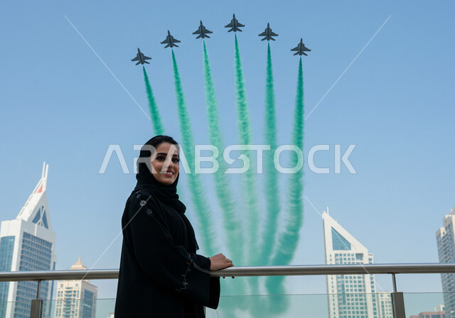  مشاهدة العرض الجوي للطائرات في احتفالات العيد الوطني، اليوم الوطني السعودي 23 سبتمبر، إمرأة عربية خليجية سعودية تشاهد تحليق الطيران الحربي في سماء المملكة العربية السعودية في ذكرى يوم العلم 11 مارس، تزيين السماء بدخان ملون 