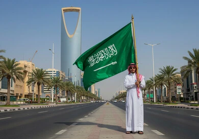  الاعتزاز والفخر بالانتماء للوطن، مناسبات واحتفالات وطنية في المملكة العربية السعودية، رجل عربي خليجي سعودي يرتدي الشماغ والثوب التقليدي يرفعالعلم وسط الطريق، اليوم الوطني السعودي 23 سبتمبر، يوم العلم 11 مارس