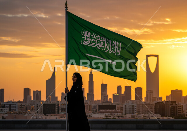 غروب الشمس فوق المدينة، الاعتزاز والفخر بالانتماء للوطن، مناسبات واحتفالات وطنية في المملكة العربية السعودية، إمرأة عربية خليجية سعودية ترتدي الحجاب والعباءة ترفع العلم وسط الطريق، اليوم الوطني السعودي 23 سبتمبر، يوم العلم 11 مارس