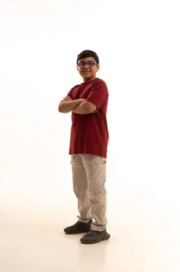 مفهوم الاهتمام بالمظهر الخارجي, الوقوف باستقامة وبأيدي متقاطعة، بورتريه لولد عربي خليجي سعودي مبتسم يرتدي الزي الكاجوال سروال وفانيلا حمراء ينظر الى الكاميرا بتعابير الفرح والسرور،الرجولة والقوة والثقة بالنفس، صورة الجسم بالطول الكامل، خلفية بيضاء