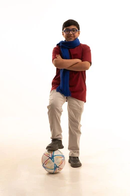 جاهز للتحدي والفوز، النظر إلى الكاميرا بروح العزيمة على الانتصار، الحماس للمنافسة وتعابير الفرح والسرور، تشجيع الفريق السعودي، بورتريه لولد عربي خليجي سعودي يرتدي الزي الكاجوال ووشاح أزرقالوقوف بايدي متقاطعة ويضع قدمه على الكرة , صورة الجسم بالطول الكامل, خلفية بيضاء