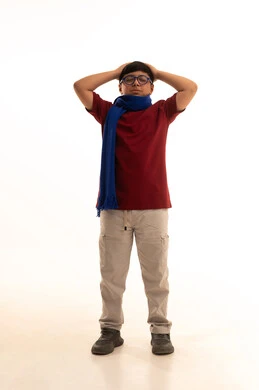 التفاجؤ من شيء ما، الشعور بالدهشة والصدمة والذهول, بورتريه  لولد عربي خليجي سعودي مبتسم يرتدي الزي الكاجوال سروال وفانيلا حمراء ينظر الى الكاميرا ينظر الى الكاميرا يضع يديه على رأسه بإيماءات التعجب والغضب, وشاح رقبة أزرق، الشعور بالسعادة والقوة، خلفية بيضاء