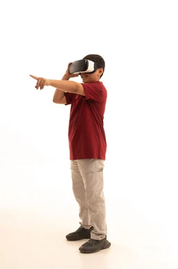 ايماءات الاندماج والتركيز، التطور التقني والتكنولوجي، محاكاة العالم الخيالي والنظر الى الافلام الواقعيه،  بورتريه لولد عربي خليجي سعودي يرتدي الزي الكاجوال سروال وفانيلا حمراء ينظر من خلال نظارات ثلاثية الأبعاد (الفي ار),  الجسم بالطول الكامل، خلفيه بيضاء